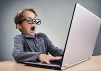 Shocked and surprised boy on the internet with laptop computer c