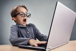 Shocked and surprised boy on the internet with laptop computer c